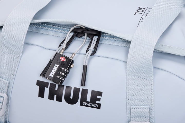 Light blue backpack with a Thule lock attached, featuring the brand name 'Thule Sweden'.